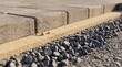 © Tatiana - Concrete paver installation layers with screeded sand and crushed aggregate sub-base, low-angle construction close-up showing proper pavement foundation