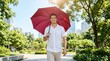 © Png guru - Confident young man walking gracefully through a lush green urban park holding a bright red umbrella during a pleasant sunny day outdoors cityscape