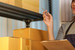 © Natee Meepian - Small business owner checking inventory of cardboard shipping boxes in warehouse