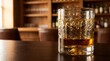 © Food_Factory - Amber whiskey poured into a textured crystal glass resting on a smooth wooden bar counter inside a cozy dark pub