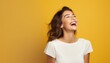 © V Art - Joyful woman laughing against a vibrant yellow background showcasing happiness and positivity in a bright atmosphere