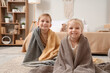 © Pixel-Shot - Little brother and sister sitting on floor under plaids at home