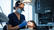 © Taras Roshchuk - A dental professional works on a patient's teeth in a bright clinic. The patient wears protective glasses while sitting in the dental chair