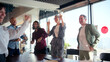 © CarlosBarquero - Enthusiastic business team celebrating success, dancing together in the office, enjoying a moment of joy and camaraderie after achieving a goal