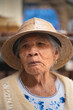 © AndreaGabriela - Portrait of an elderly woman wearing a traditional straw hat inside a store