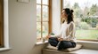 © Ema Ariska Barus - Peaceful young woman practicing mindfulness meditation while sitting on a windowsill at home, enjoying a quiet morning with natural light