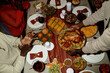 © Seventyfour - African American young adults sharing Thanksgiving dinner at home, hands serving roasted turkey. High angle view of festive holiday meal, ideal for seasonal family marketing campaigns