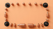 © ABDUL - Cosmetic bottles and dropper vials arranged as a frame on a peach background