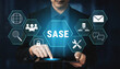 © InfiniteFlow - Business Professional Engaging with Digital Icons Representing SASE Technology and Network Security Solutions in a Modern Office Environment. Glyphic.