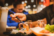 © PixelPlex - Diner lifting fresh salmon sashimi with chopsticks