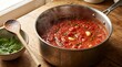© Nextzen Creative - Fresh tomato sauce simmering in a large stainless steel pot on a wooden kitchen counter at home. marinara cooking tips