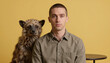 © jockermax3d - Young man with buzz cut posing with a striped hyena pup