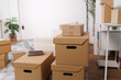 © David - Cardboard boxes stacked in a bright, modern living room, symbolizing moving, relocation, new beginnings, home organization, delivery services, and housewarming