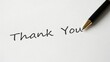 © Creative workshop  - A black pen writes thank you in cursive handwriting on white paper. Ideal for gratitude greeting cards and appreciation messages.