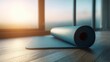 © Ismail - Rolled yoga mat on wooden floor with soft morning sunlight through window