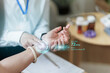 © Natee Meepian - Doctor checking patient pulse with digital heart rate overlay for health monitoring
