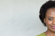 © Wavebreak Media - African woman posing with gold hoop earring, wearing green top in studio on right, copy space