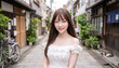 © Jesse_4160 - Young Asian woman with long brown hair wearing a white off-shoulder dress smiling in a charming Japanese alleyway with traditional buildings