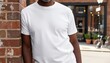 © QuoDesign - Older man wearing a blank white t shirt leaning against a brick building wall