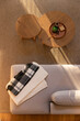 © Wavebreak Media - Overhead light beige sofa chaise is featuring folded blankets and nesting wooden tables on rug