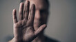 © Rhallyson - A blurred man holds his open palm towards the camera in a protective gesture, signaling a stop, rejection, or setting personal boundaries.