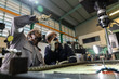 © eakgrungenerd - Industrial manufacturing inspection concept. Two engineers inspect CNC machinery with flashlight in factory, focusing on precision, safety, quality, engineering.