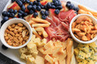 © ir1ska - ham, blue cheese, peanuts and snack platter with fruits nuts and meats on a white tray at a gathering