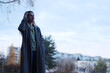 © Тарас Белецкий - Young woman in a long coat and cardigan looking thoughtfully into the distance outdoors