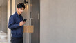 © Stock Photo - 届け先をスマートフォンで確認する若い日本人配達員と右側の余白