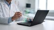 © Wankatsu - Male doctor interacting with a digital clipboard hologram on a laptop using a stylus for healthcare digitization and patient record management concept.