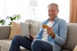 © Prostock-studio - Smiling Senior Caucasian Man Using Laptop While Holding Credit Card For Online Shopping At Comfortable Living Room. Enjoying Convenience Of Digital Payment Options At Home. Business Concept.