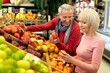 © Prostock-studio - Smiling Elderly Caucasian Man And Woman Shopping Together In Supermarket, Choosing Fresh Organic Fruits, Enjoying Their Time While Holding Fruits At Store. Positive Senior Couple Moment.