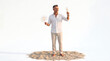 © Davi Alves - Man holding champagne and sparkler on sand celebrating with joy and excitement isolated on white background