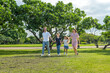 © BESTIMAGE - Happy family Holding Hands walking together outdoors joyful enjoying bonding moment in nature. Multigenerational family strolling in park outdoor fun lifestyle relaxing smiling walking connection
