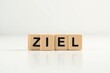 © hamzah - Zieleinlauf mit Holzbuchstaben als minimalistisches Konzept für Zielerreichung