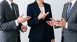 © Avery - Corporate business team discussion featuring three professionals in formal suits gesturing during meeting, negotiation conversation, partnership agreement dialogue