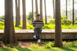 © Yic Ma/Stocksy - Young man working on laptop outdoors