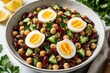 © Maryna - Mixed bean salad with cucumber and egg halves in bowl. Healthy protein rich dish with fresh herbs and lemon garnish. Delicious vegetarian meal for lunch.