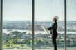 © BESTIMAGE - architect woman reading blueprint thinking planning project interior on empty office interior near glass window. office architect standing reading blueprint on skyscraper floor construction workplace