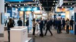 © Wannaeka - Blurred view of a busy trade show floor with people at information stands in a large convention center.