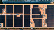 © pattozher - Rooftop Solar Array: An aerial view showcases a vast solar panel installation on the roof of a modern building, harnessing clean energy from the sun.