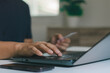 © MUNTHITA - Online shopping concept. A man holding credit card and typing on laptop for online shopping and payment makes a purchase on the Internet, Online payment, Business financial and technology.