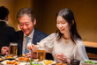 © maroke - 若い女性と二人で食事をする中年のビジネスマン