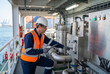 © VectorVille - Engineer checking control panel on cargo ship in industrial setting
