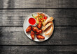 © Westend61 - Plate of chicken wing with bread and salad on wooden table