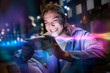 © Westend61 - Smiling woman holds mobile device with glowing AI light in city