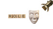 © LABONI - Wooden blocks spelling the word role next to a theatrical mask under a spotlight isolated on transparent background