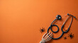 © NeuroFrame - Halloween medical flat lay with stethoscope skeleton hand and spiders