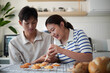 © matinee - Asian couple decorating freshly baked cookies with colorful icing.