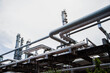 © Rangsarit - Industrial oil and gas pipeline rack structure at petrochemical processing facility